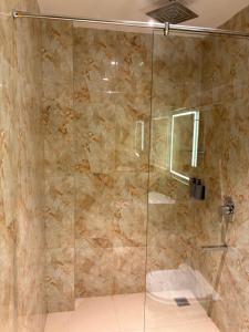 a bathroom with a shower with a glass door at The Citi Residenci Hotel, Bidhannagar in Durgāpur +106 photos