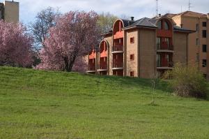 a building on top of a grassy hill at Residence Le Volte Apartments in Parma