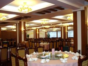 einen Bankettsaal mit Tischen, Stühlen und Kronleuchtern in der Unterkunft Century Land Hotel Wuyishan in Ch'ung-an-hsien