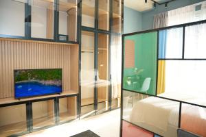 地拉那Ambassador Skyline Apartments的一间卧室，墙上有一张床和一台电视