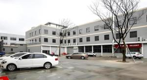 a white car parked in a parking lot in front of a building at Jinjiang Inn Style Xiangshan Bus Station in Xiangshan