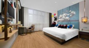 um quarto com uma cama grande e uma TV em Magnotel Business Harbin Railway Station Qiulin Museum Metro Station em Harbin