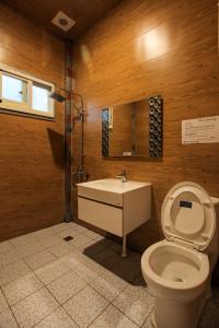 a bathroom with a toilet and a sink and a mirror at Kenting Dream House in Kenting