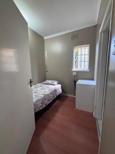 a small room with a bed and a window at The Easy Stay in Durban