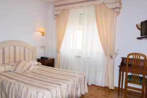 1 dormitorio con cama y ventana grande en Hotel Avenida III, en Villadangos del Páramo