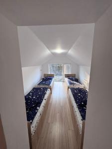 a room with three beds in it with a window at Casa Denisa Vidraru transfgarasan in Căpăţîneni-Ungureni