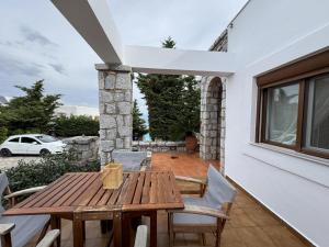ein Holztisch und Stühle auf einer Terrasse in der Unterkunft Jassemi Studio in Mavrovouni