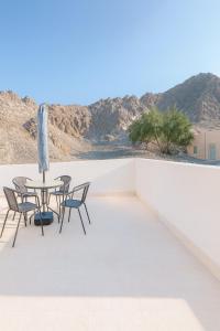a patio with a table and chairs and a view of the desert at Sikka Hostel in Muscat