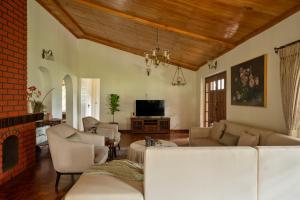 a living room with a couch and a fireplace at SaffronStays Oakridge Cottage in Coonoor