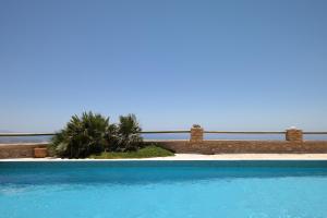 a blue swimming pool with a palm tree in the background at Keramos Villa in Kerames