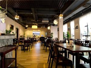 Un restaurante con mesas y sillas de madera en una sala. en Zhuhai Aqueen Hotel, en Zhuhai