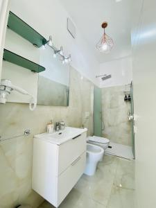 une salle de bains blanche avec toilettes et lavabo dans l'établissement Corso 42, à Novara