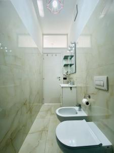 une salle de bains blanche avec toilettes et lavabo dans l'établissement Corso 42, à Novara