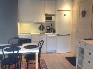 cocina con mesa, sillas y nevera en Lumi City Apartment en Levi