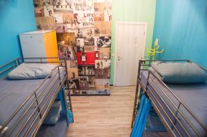 Dos literas en una habitación con una pared con cuadros. en Victoria House Hostel, en Génova