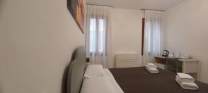 a white room with a bed and a desk and window at Palazzetto Canossa in Venice