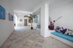 ein Flur mit zwei blauen Sofas und einer Palme in der Unterkunft Hotel Cutimare - Aeolian Charme in Acquacalda