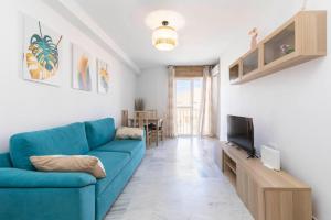 a living room with a blue couch and a television at apartamento Cabo de Gata in El Cabo de Gata