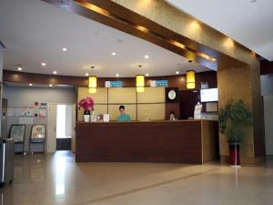 南京市にあるJinjiang Inn Nanjing Xinjiekou Traditional Chinese Medicine Hospital Chaotiangong West Streetのレストランのカウンターに立っている男性