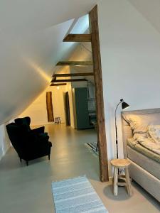 Una sala de estar con una silla negra y una cama. en Nygård Apartments, en Klagstorp