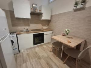 uma pequena cozinha com uma mesa e uma pia em Il Rifugio Del Nostromo em Mola di Bari