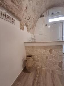uma cozinha com uma parede de pedra e um vaso no chão em Il Rifugio Del Nostromo em Mola di Bari mais 32 fotografias