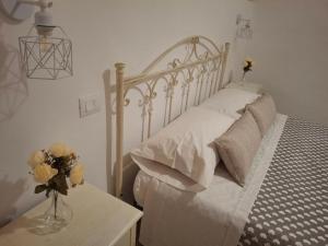 um quarto com uma cama com um vaso de flores sobre uma mesa em Il Rifugio Del Nostromo em Mola di Bari