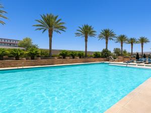 ラスベガスにあるTrump International Hotel Las Vegas, a Hilton Grand Vacations Club- STUDIO STPのヤシの木が背景に浮かぶスイミングプール +3枚の写真
