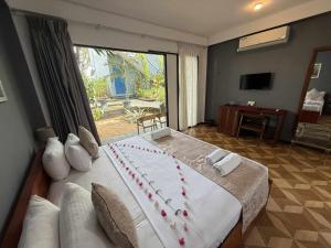 um quarto com uma cama grande e uma janela grande em Endlessblue Resort Kalametiya em Kalametiya