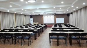 uma sala grande com mesas e cadeiras e uma tela em 7 Days Inn Qingdao Haier Zone Ditie Tower Jiushui West Road em Laoshan