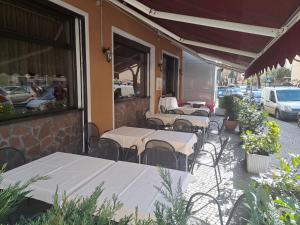 una fila de mesas y sillas fuera de un restaurante en B&B Hotel Dolomiti, en Bolzano