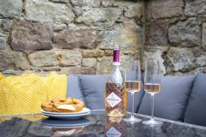 a bottle of wine and two glasses on a table at Northern Hideaways St Cuthberts, Seahouses in Seahouses +106 photos