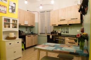 a kitchen with wooden cabinets and a table in it at Victoria House Hostel in Genoa
