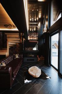 een woonkamer met een bank en een open haard bij Chaletovo Mountain Residences in Zakopane