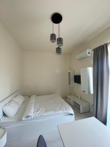 a bedroom with a white bed and two lights at VISAJ Residence in Timişoara +39 photos