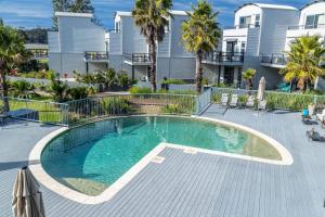 a swimming pool in front of a apartment building at Corrigans Poolside Apartment Batehaven in Batehaven