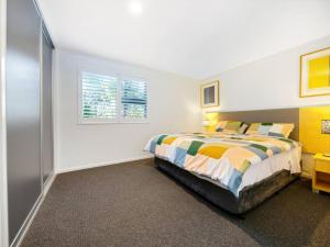 a bedroom with a bed and a window at Corrigans Poolside Apartment Batehaven in Batehaven +17 photos