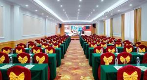 uma sala de conferências com mesas verdes e cadeiras vermelhas em Vienna 3 Best Hotel Shenzhen Bantian Guangya Park Metro Station em Shenzhen