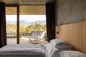 una camera da letto con un letto, una sedia e una finestra di Füchslhof a Marlengo