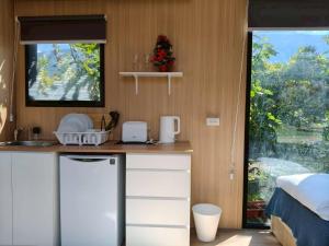 una cucina con bancone, lavandino e finestra di Cloudview Cottages by Tiny Away a Huan-shan