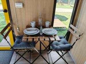 un tavolo con sedie, piatti e una bottiglia sopra di Cloudview Cottages by Tiny Away a Huan-shan