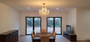 a dining room with a table and a chandelier at Redhill Batemans Bay in Batemans Bay