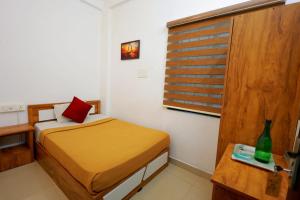 een kleine kamer met een bed en een raam bij Calicut residency in Kozhikode