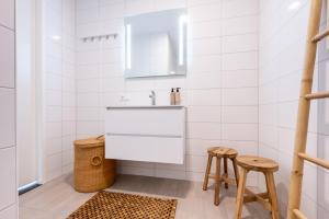 Un baño con un lavabo y dos taburetes. en Luxe apartment in recidence marina uithaven 1C, en Kamperland 12 fotos más