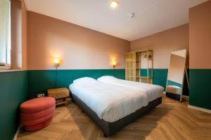 Un dormitorio con una cama grande y una silla. en Luxe apartment in recidence marina uithaven 1C, en Kamperland