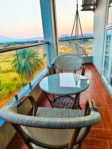 a table and chairs on a balcony with a view at Friendz Villa in Igatpuri