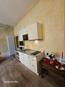een keuken met witte kasten, een wastafel en een tafel bij Appartamento Signoria in Florence