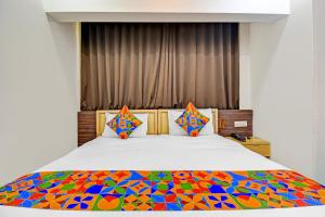 a bedroom with a bed with a colorful comforter at FabHotel The Walnut in Pune