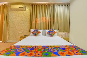 a bedroom with a large bed with a colorful comforter at FabHotel The Walnut in Pune