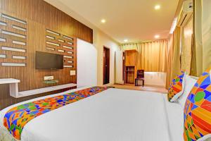 a bedroom with a bed and a tv on a wall at FabHotel The Walnut in Pune +25 photos